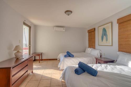 a bedroom with two beds with blue pillows on them at Ocean and Mountain View Villa in Playa Hermosa