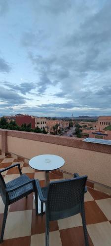 a patio with two chairs and a table on a balcony at Residence Imlil Ouarzazate in Ouarzazate