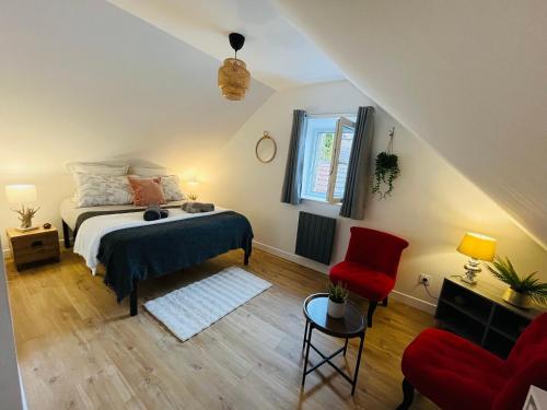 une chambre avec un lit et une chaise rouge dans l'établissement Le Havre d'Olga - Homillesime, à Dijon