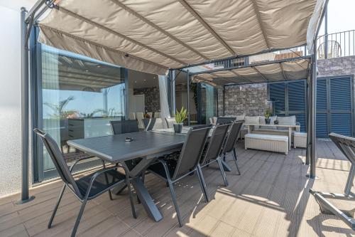 a patio with a table and chairs on a deck at Flowers island house 5 in Funchal