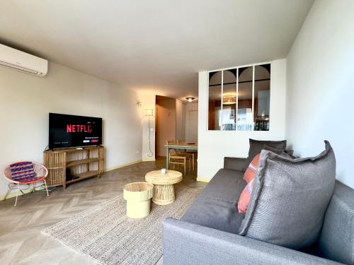 un salon avec un canapé et une télévision dans l'établissement Le Montébello By SCLS Locations, à Cannes