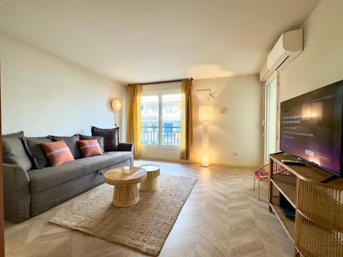un salon avec un canapé et une télévision dans l'établissement Le Montébello By SCLS Locations, à Cannes
