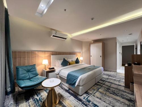 una habitación de hotel con una cama y una silla en فندق ليوبارد الفندقية Leopard Hotel, en Najrán