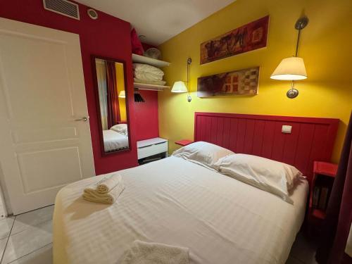 - une chambre rouge et jaune avec un lit et un miroir dans l'établissement A079 Appartement confortable sur Carnot -1 chambre, à Cannes