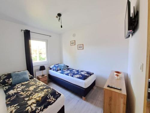 a bedroom with two beds and a window at Domki Kajuta 3 in Żarnowska
