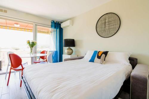 sypialnia z dużym łóżkiem, stołem i krzesłami w obiekcie SELECT'soHOME - Studio au cœur du centre-ville du Lavandou à quelques pas de la plage ! - Services hôteliers - AREV w mieście Le Lavandou