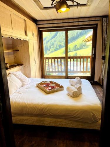 - une chambre avec un lit, des serviettes et une fenêtre dans l'établissement Apt 8p, ski-in, ski-out, parking, à Méribel