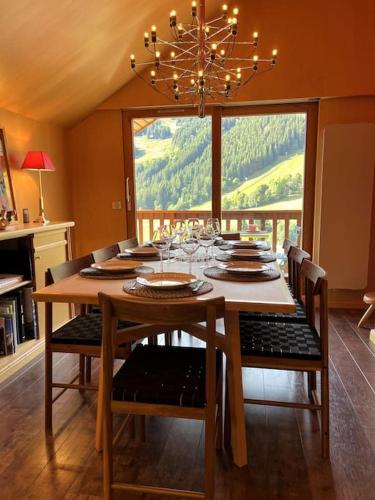 une salle à manger avec une table, des chaises et un lustre dans l'établissement Apt 8p, ski-in, ski-out, parking, à Méribel