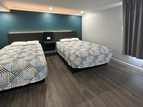 two beds in a hotel room with two bedsskirtspectspectspectssenalsenalsenal at Motel 6 Buena Park, CA Anaheim Near Maingate Knotts in Buena Park