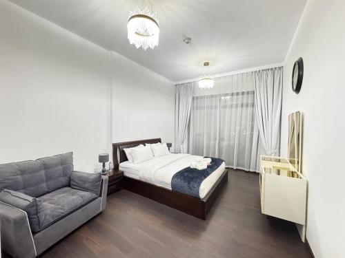 a bedroom with a bed and a couch at Stay in the heart of Sport City in LUX 1BDR with sky view 11 in Dubai
