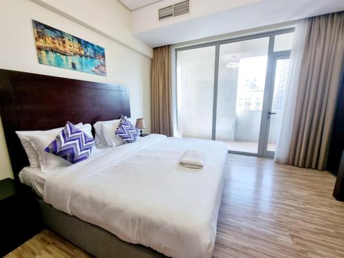 a bedroom with a large bed with blue and white pillows at Aspire Tower # Two Bedroom Luxury Suite Juffair in Manama