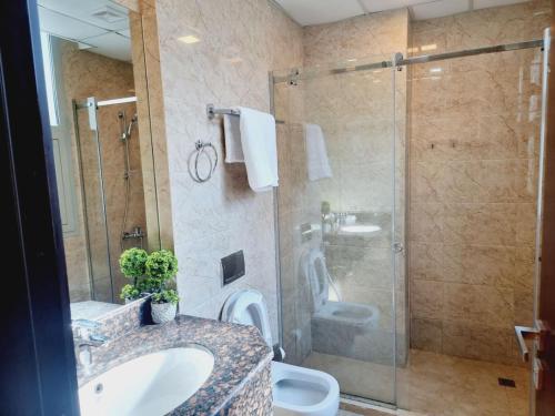 a bathroom with a toilet and a sink and a shower at Aspire Tower # 7th Floor 2 Bhk Paradise Suite in Manama