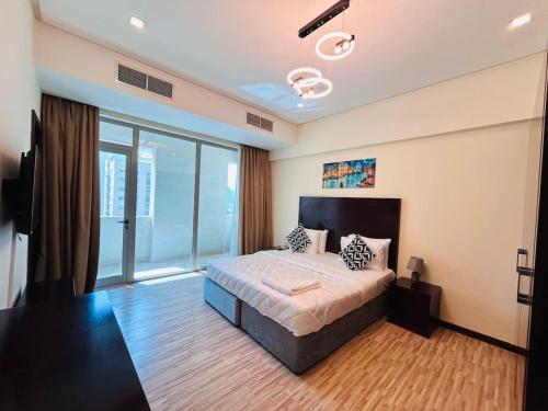 a bedroom with a bed and a large window at Aspire Tower - Two Bedroom Sunny Staycation in Manama