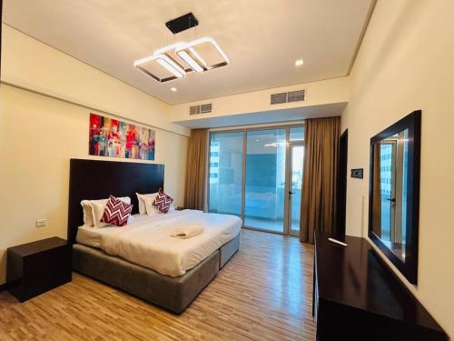 a bedroom with a large bed and a television at Aspire Tower - Breezy Two Bedroom in Juffair in Manama