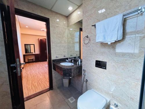 a bathroom with a sink and a toilet at Aspire Tower - Breezy Two Bedroom in Juffair in Manama