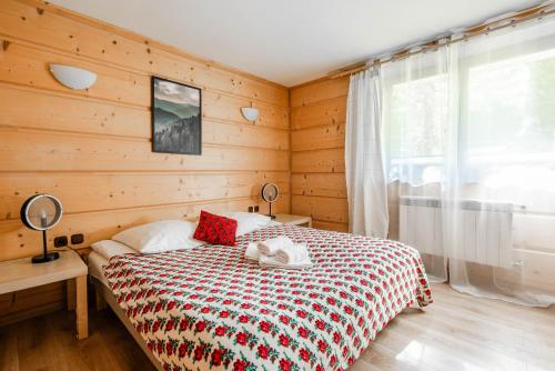 een slaapkamer met een bed met een houten muur bij Willa Marta Zakopane in Zakopane