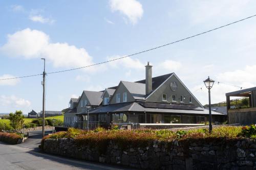 Casa grande con pared de piedra en Doolin Inn, en Doolin