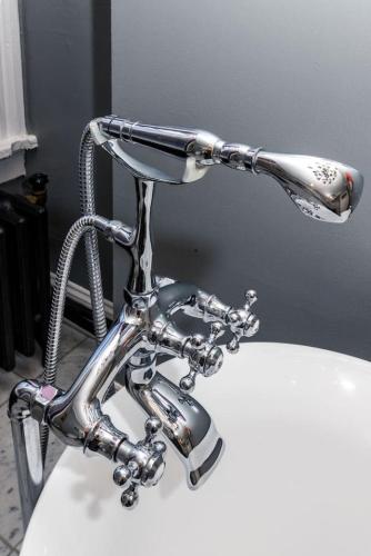a bathroom sink with a faucet on top of it at Luxury Brownstone - Walk to ALL - Washington Park in Cincinnati
