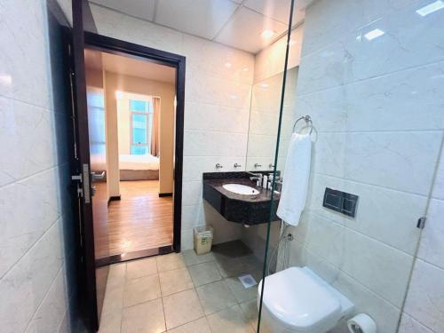 a bathroom with a toilet and a sink and a shower at Aspire Tower # Peaceful Pad Juffair in Manama
