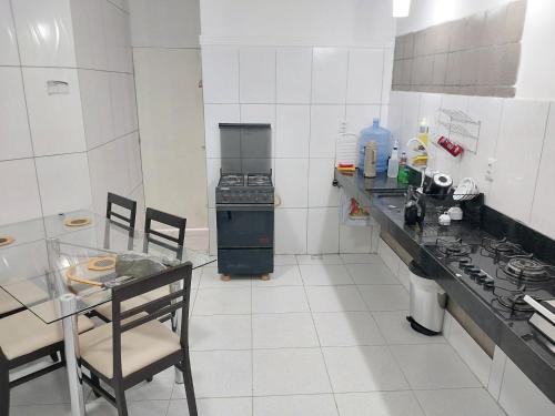 a kitchen with a counter and a table and a stove at Fênix hospedaria in Natal