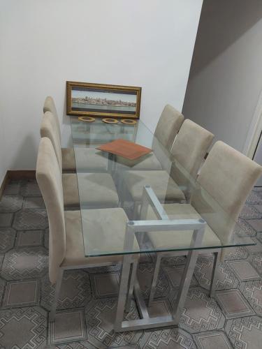 a glass table and chairs in a room at Fênix hospedaria in Natal