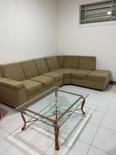 a living room with a couch and a glass table at Fênix hospedaria in Natal