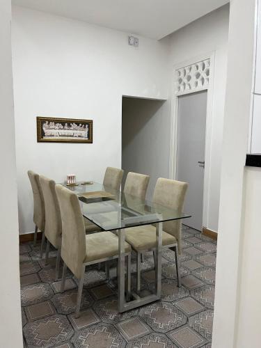 a dining room with a glass table and chairs at Fênix hospedaria in Natal