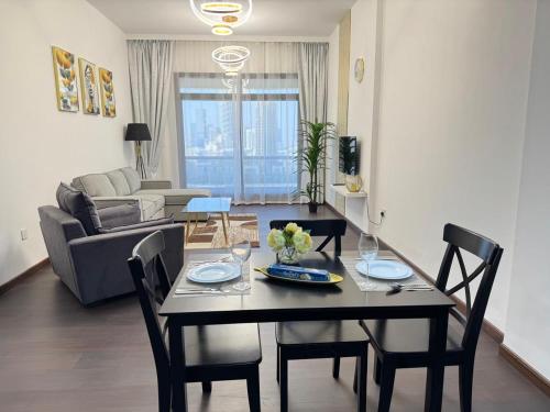 a living room with a dining room table with chairs at Stay in the heart of Sport City in LUX 1BDR with sky view 11 in Dubai