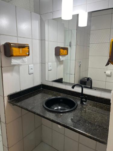 a bathroom with a sink and a mirror at Fênix hospedaria in Natal