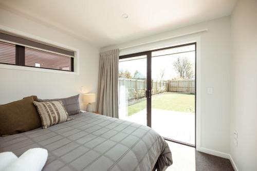 a bedroom with a bed and a sliding glass door at Family Friendly on Forest Drive in Methven