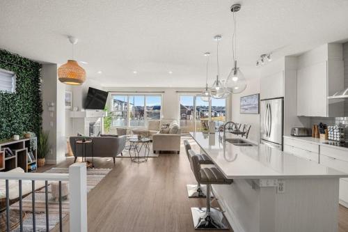 a kitchen and living room with white cabinets and a counter at 3 Bedroom Sage House with AC, Driveway Parking, King Bed & More in Calgary