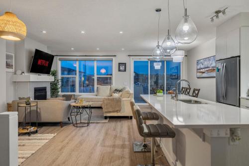 a kitchen and living room with a counter and a living room at 3 Bedroom Sage House with AC, Driveway Parking, King Bed & More in Calgary