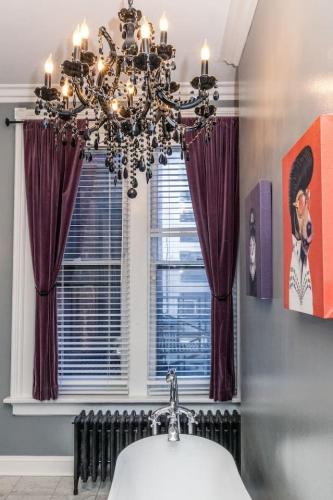 a bathroom with a chandelier and a sink and a window at Luxury Brownstone - Walk to ALL - Washington Park in Cincinnati