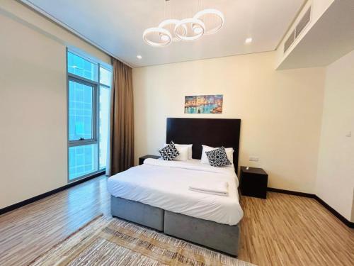a bedroom with a bed and a chandelier at Aspire Tower # Peaceful Pad Juffair in Manama