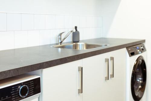 a kitchen with a sink and a washing machine at Family Friendly on Forest Drive in Methven