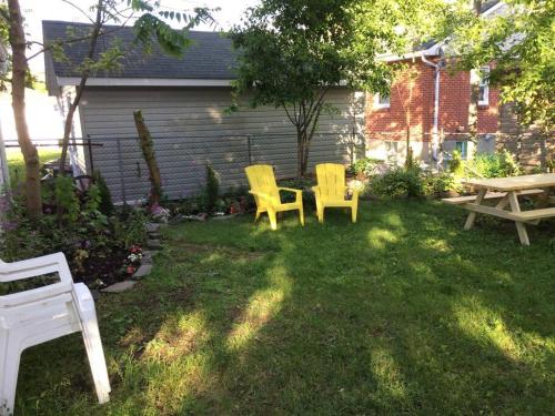 two yellow chairs and a picnic table in a yard at Charming Farmhouse in the City, Near Wine Country in Belleville