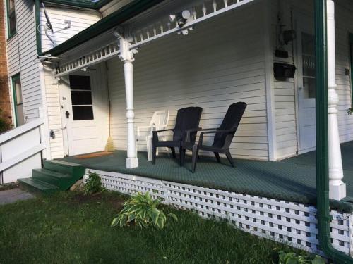 two chairs sitting on the front porch of a house at Charming Farmhouse in the City, Near Wine Country in Belleville
