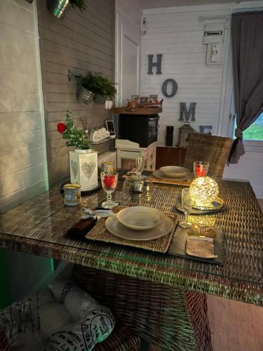 une table avec des assiettes et des verres à vin dessus dans l'établissement l idylle chalet, à Biscarrosse