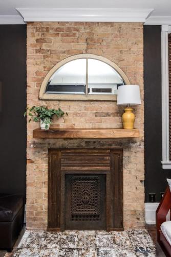 a brick fireplace with a window on top of it at Luxury Brownstone - Walk to ALL - Washington Park in Cincinnati