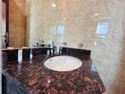 a bathroom with a marble counter with a sink at Aspire Tower -Chic City Escape Juffair in Manama