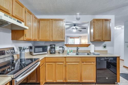 a kitchen with wooden cabinets and a sink at Lincoln Apartment with Balcony 2 Mi to Loon Mtn! in Lincoln
