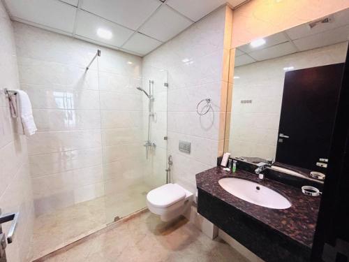 a bathroom with a toilet and a sink and a shower at Aspire Tower # Serenity Suite Juffair in Manama
