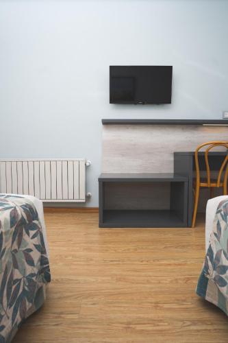 a living room with two chairs and a flat screen tv at Hotel Bahia Nueva in Puerto Madryn