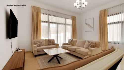 a living room with a couch and a table at Al Dana Paradise Luxury Villas Palm Fujairah Sea View in Fujairah