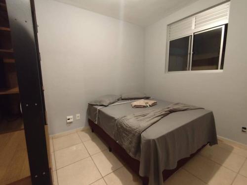 a bedroom with a bed in a white room at Divino Apartamento Sete lagoas in Sete Lagoas
