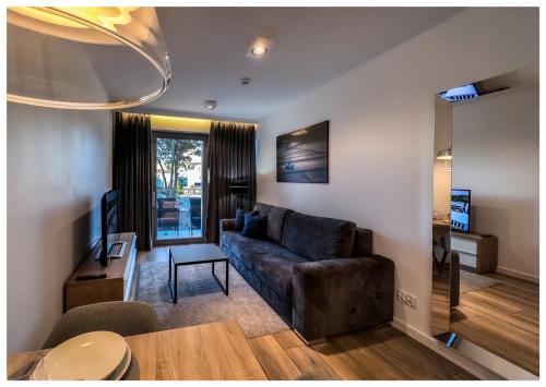a living room with a couch and a table at Balticus Playa Margarita in Międzyzdroje