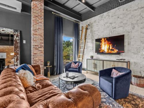 a living room with a couch and a fireplace at Luxury Loft - Downtown Tampa, Ybor, Armature in Tampa