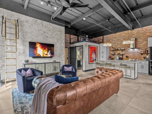 a living room with a large couch and a kitchen at Luxury Loft - Downtown Tampa, Ybor, Armature in Tampa