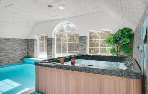 Un baño grande con bañera y piscina. en Nice Home In Ulfborg With Sauna, en Ulfborg