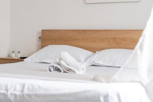 a white bed with white sheets and pillows at Central Vila 5 in Durrës